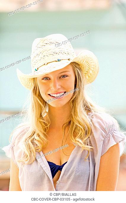 Portrait of Young Woman with Straw Hat Looking at Camera