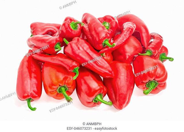 Pile of the freshly harvested different red bell peppers and red chili on a white background