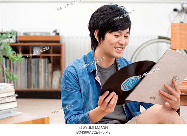 Portrait of young man holding vinyl record