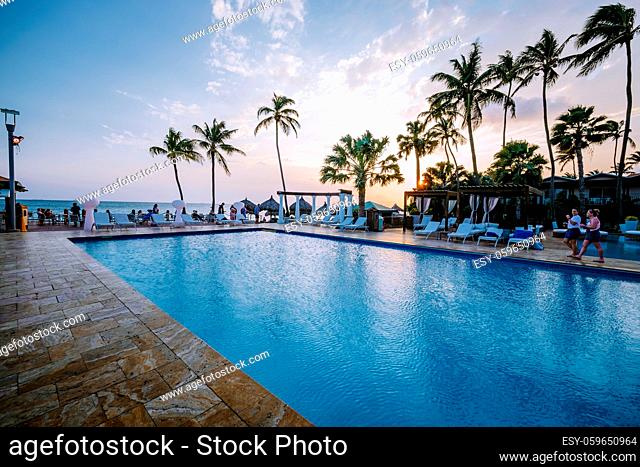 Aruba Caribbean white beach with palm trees and luxury swimming pool Aruba Caribbean sea