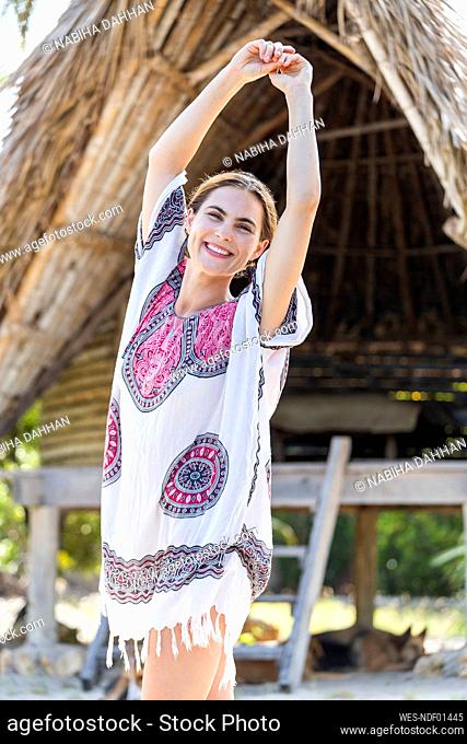 Happy woman dancing at beach on vacation
