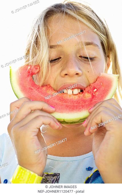 Girl eating slice of watermelon, close-up