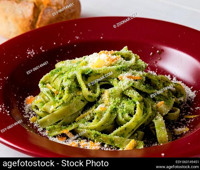 fresh green vegetarian tagliatelle dish in red plate