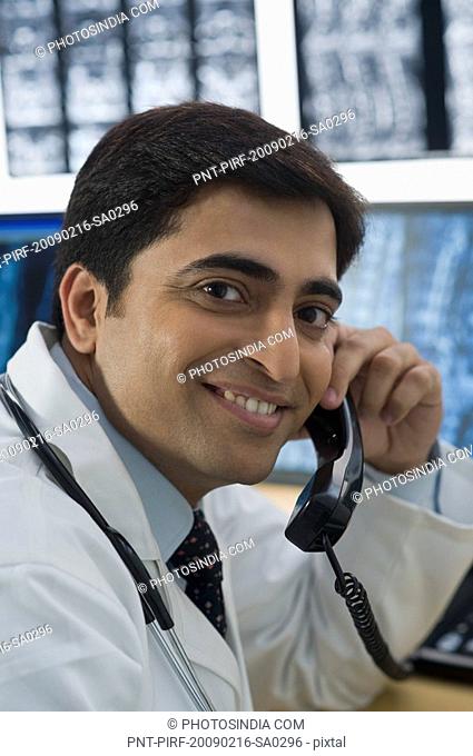 Male doctor talking on a phone and smiling