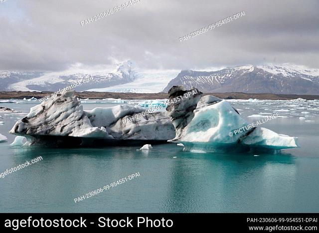 FILED - 12 April 2023, Iceland, Jökulsarlon: Icebergs float in Iceland's glacial lake Jökulsarlon, while a spur of the Vatnasjökull glacier can be seen in the...