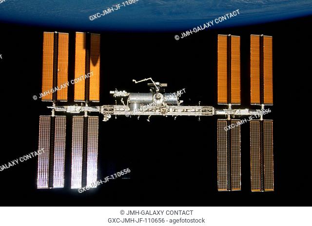 Backdropped by the blackness of space and Earth's horizon, the International Space Station is seen from Space Shuttle Endeavour as the two spacecraft begin...
