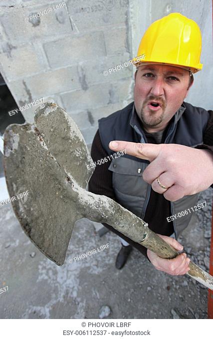Tradesman pointing to a worn out spade
