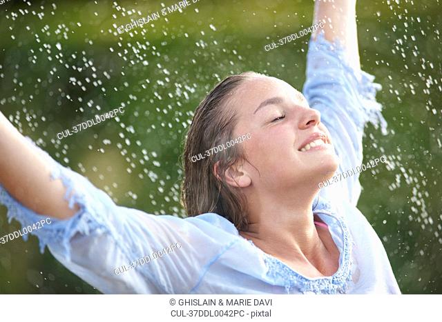 Woman playing in sprinkler