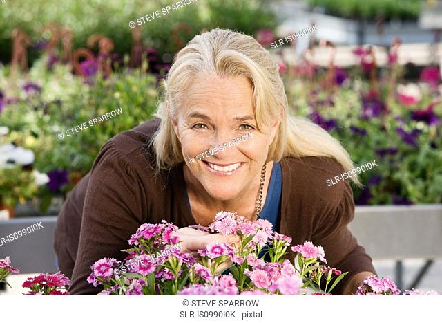 Woman with flowers at garden centre