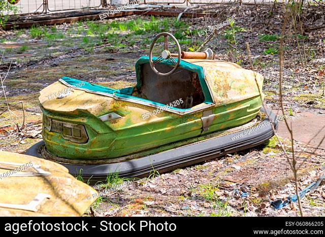 Old broken rusty metal radioactive children's electric cars abandoned, the park of culture and recreation in the city of Pripyat, the Chernobyl disaster