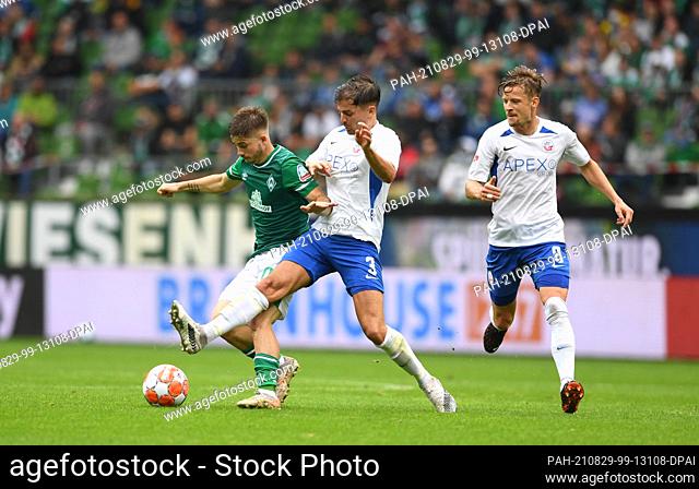 29 August 2021, Bremen: Football: 2. Bundesliga, Werder Bremen - Hansa Rostock, Matchday 5. Werder's Romano Schmid (l) fights for the ball against Rostock's...