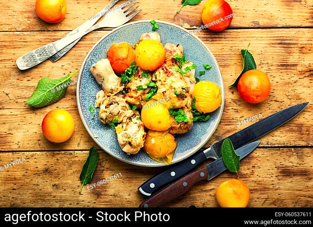 Chicken drumstick stuffed with plum and cherry plum. Baked meat dish with fruit