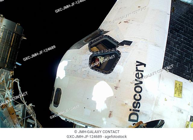 This scene, showing the cabin of Space Shuttle Discovery while docked with the International Space Station, was photographed by one of the space walking...