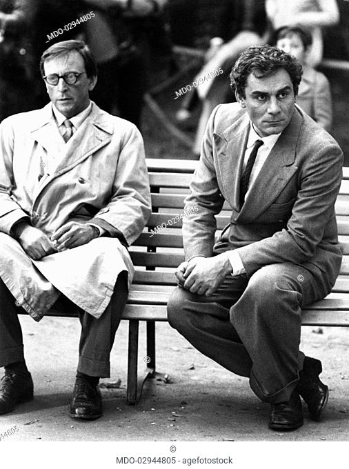 Italian actor and scenarist Gian Maria Volonté sitting on a bench with Italian actor Felice Andreasi in The Suspect. Milan, 1975