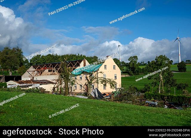 22 September 2023, Rhineland-Palatinate, Nusbaum: Debris lies next to a residential house and a farm building that were damaged by a tornado the day before