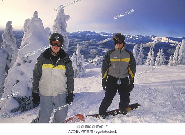 Mt  Washington Ski Resort Two teenage snowboarders with Mt  Albert Edward and Strathcona Park beyond, Vancouver Island, British Columbia, Canada