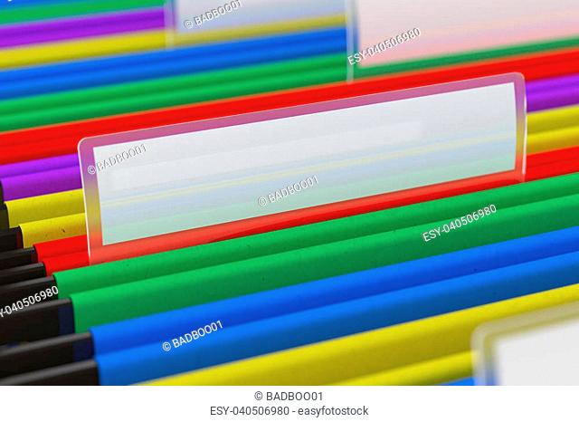 Multi colored hanging folder with blank tag on it