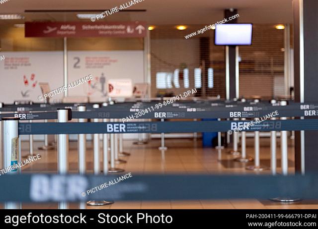 09 April 2020, Brandenburg, Schönefeld: Barrier tapes are set up in the departure terminal L of Schoenefeld Airport at 14
