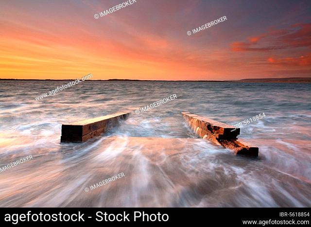 Remains of a slipway for boat builders at the mouth of the river, almost submerged by the incoming tide at sunset, River Torridge, Watertown, near Appledore