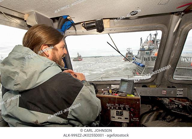 Skipper jokes with his crew on while waiting to deliver the morning's catch in Ugashik Bay, Bristol Bay region, Southwest Alaska, Summer
