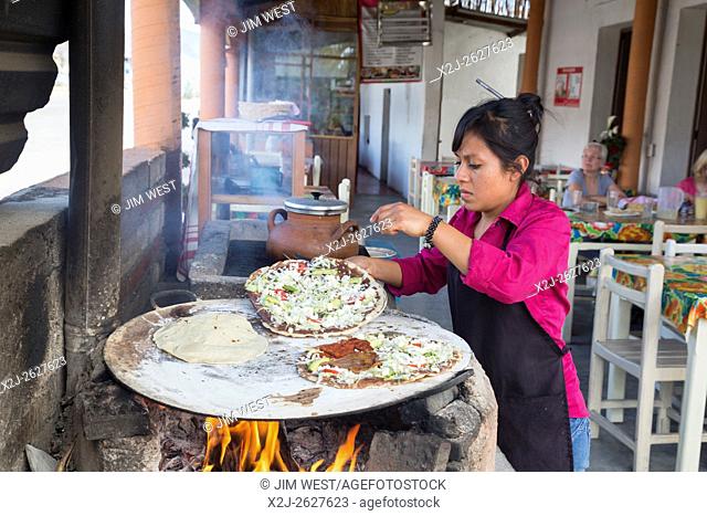 Santiago Matatlán, Oaxaca, Mexico - A worker makes tlayudas on a comal in a Oaxaca restaurant
