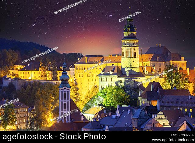 Cesky Krumlov, Czech Republic. Amazing Bright Starry Sky Castle Tower And Old Town Cityscape Skyline. Famous Landmark In Autumn Evening Night Scenic View