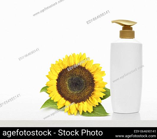 Sunflower products and shampoo bottles on white table