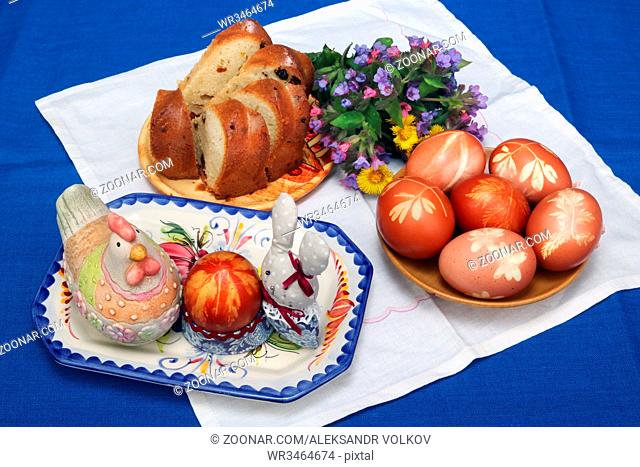 VILNIUS, LITHUANIA -APRIL 16, 2017: The easter rural composition on a table. Traditional colored eggs, Easter cake, forest wild flowers