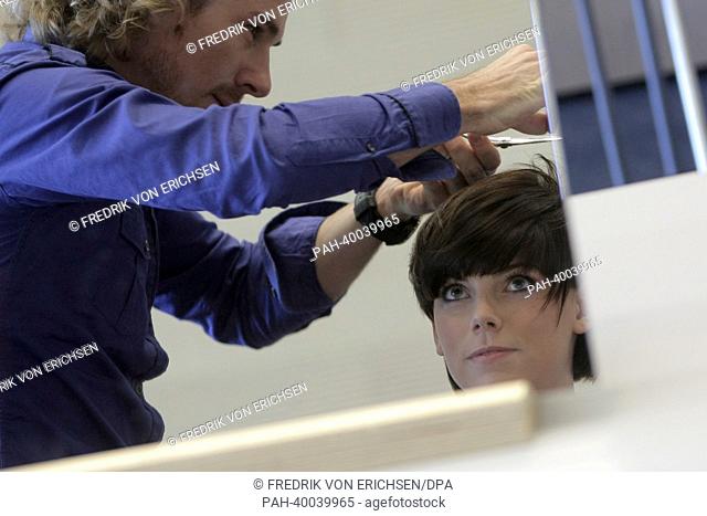 A hairdresser finishes off the new haircut trend 'Dr Bob' of model Vanessa at the fair 'Hair and Beauty 2013' in Frankfurt/Main, Germany, 06 June 2013