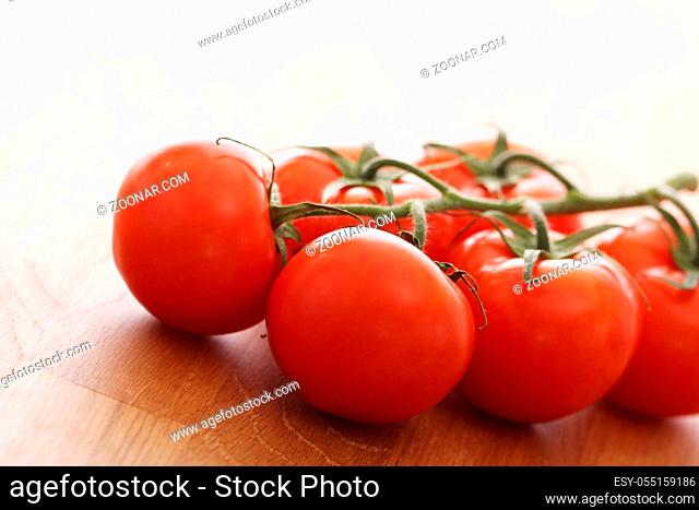 Close up of fresh tomatoes on wooden surface