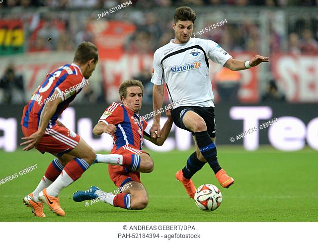 Munich's Rafinha (L) and Philipp Lahm vie for the ball with Paderborn's Moritz Stoppelkamp during the Bundesliga soccer match between Bayern Munich and SC...