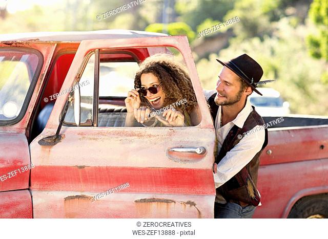 Happy young couple at old pick up truck