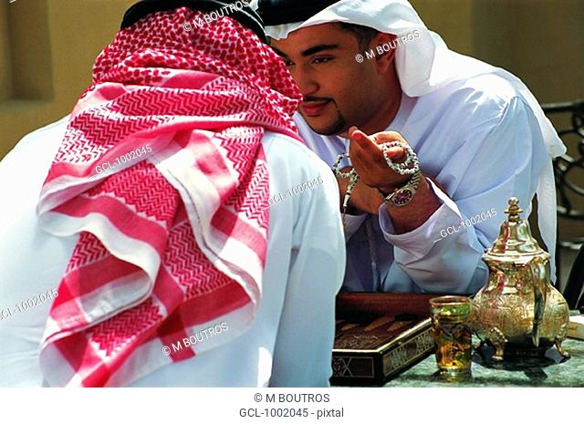 Arab men enjoying tea and a game of backgammon