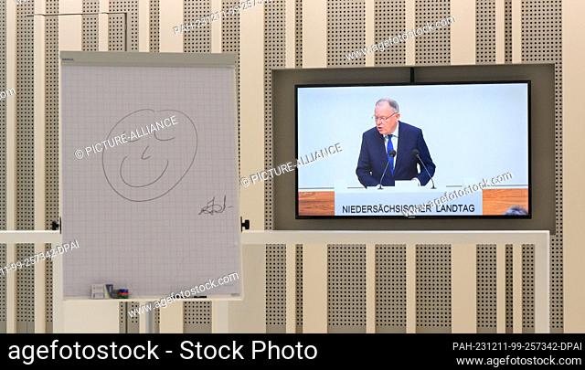 11 December 2023, Lower Saxony, Hanover: Stephan Weil (SPD), Minister President of Lower Saxony, can be seen on a monitor in the Lower Saxony state parliament...