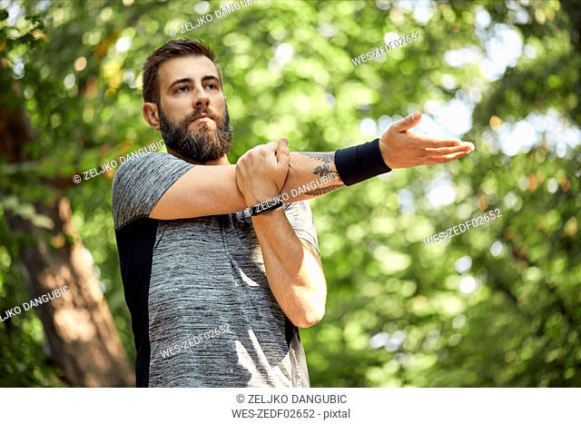 Sporty man stretching in nature