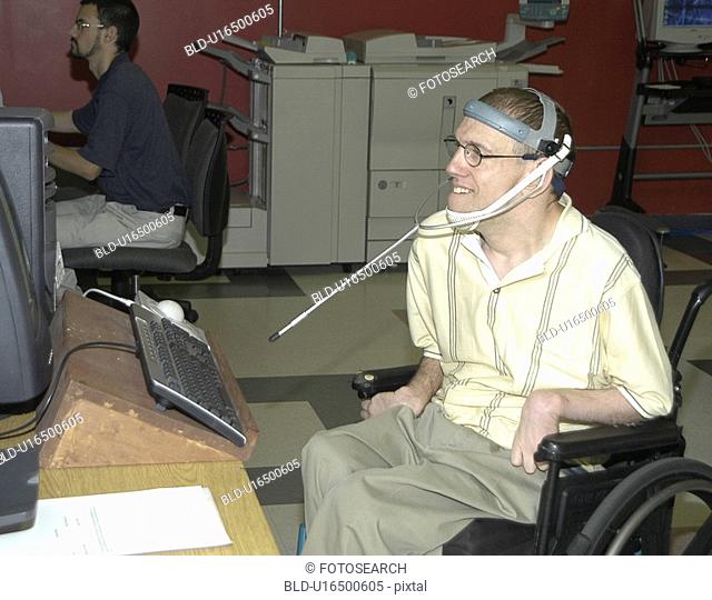 Man with significant disabilities utilizing headgear to operate communications apparatus