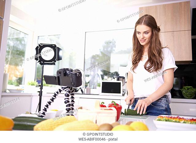 Woman recording while chopping a courgette