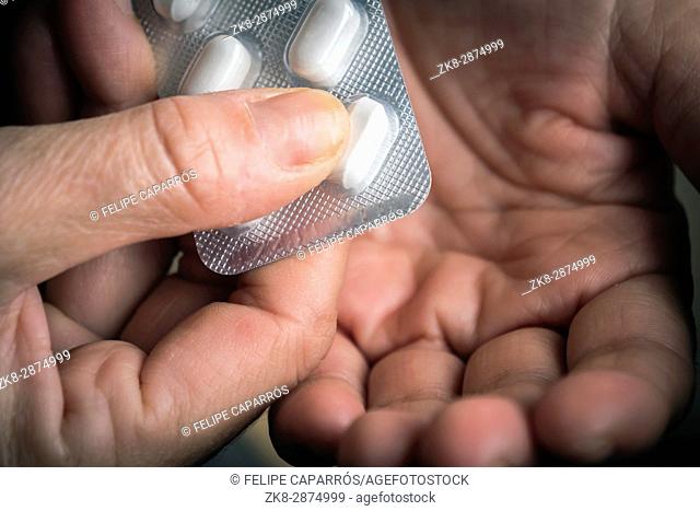 Women take white pill with left hand from a tablet pills