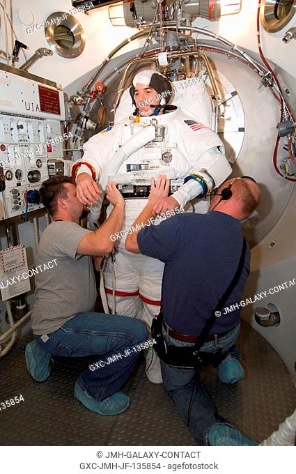 Astronaut Rex J. Walheim, STS-122 mission specialist, participates in an Extravehicular Mobility Unit (EMU) spacesuit fit check in the Space Station Airlock...