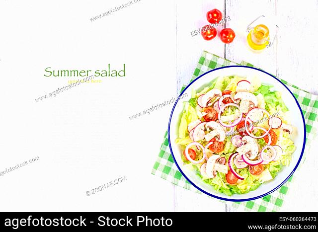 Healthy fresh summer salad with letucce, radish, cherry tomatoes, red onion and champignons with italian herbs on a wooden background with olive oil