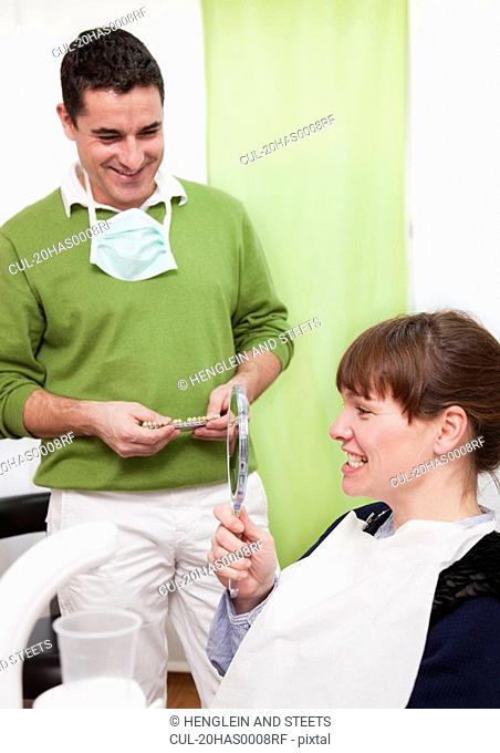 Patient examining teeth in surgery