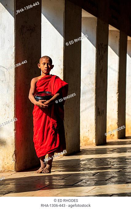 Novice Buddhist monk holding a bowl in Shwezigon Pagoda in Nyaung U, Bagan (Pagan), Myanmar (Burma), Asia