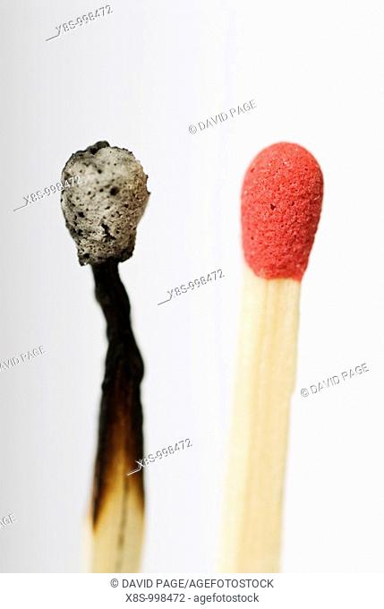 Stock photo of a live red match head next to an old burnt out match head  Conceptual image to illustrate before, after - old, new - change, dare to be different