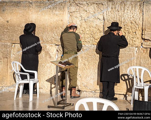 19 December 2022, Israel, Jerusalem: Believers and a soldier pray on the Temple Mount in Jerusalem at the Wailing Wall. Photo: Frank Rumpenhorst/dpa/Frank...