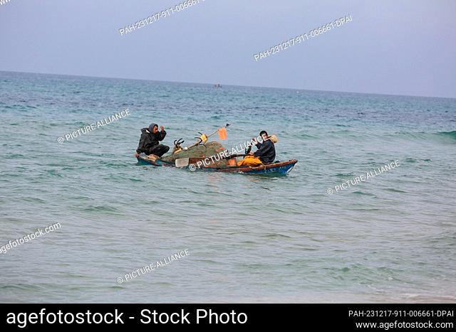 17 December 2023, Palestinian Territories, Rafah: Palestinian fishermen go fishing taking a risk to feed their families as Israeli gunboats are close to the...