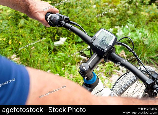 Senior man with e-bike, cyclometer
