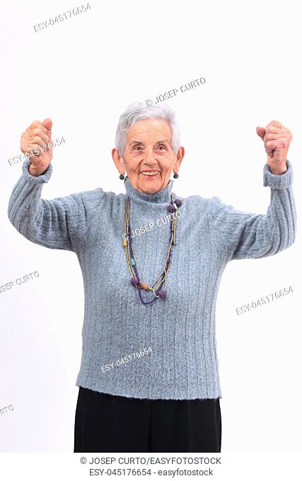 senior woman raising her arms and smiling in victory sign on white background