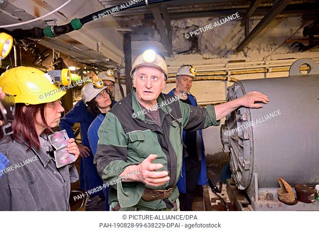 08 August 2019, Sankt Joachimsthal: Jiri Pihera, the head of the mine Unity in the Czech spa and mining town, points during a guided tour to one of the pumps...