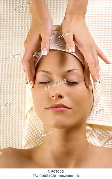cute woman in a spa getting an hands massage for the headache