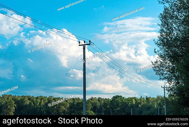 old high-voltage tower against the blue sky in the countryside